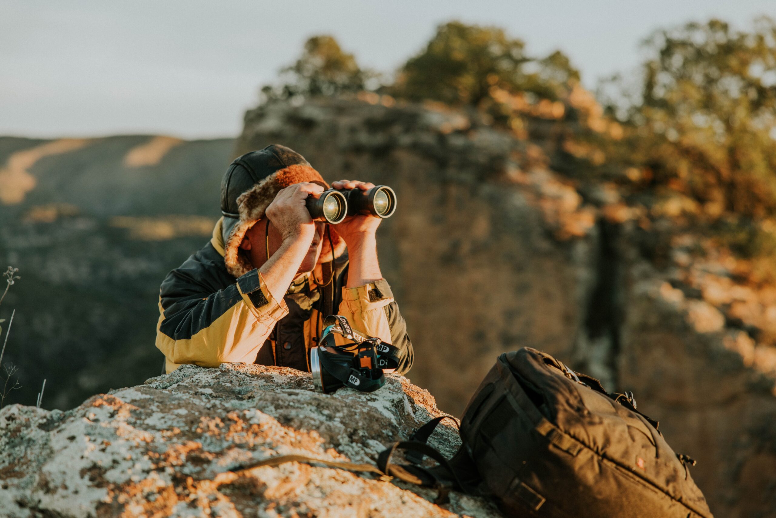 Woman scanning the night sky with binoculars, choosing the best binoculars for stargazing
